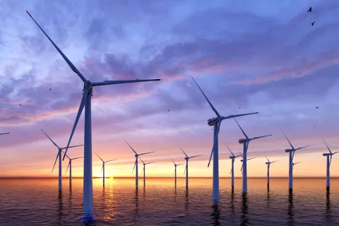 Ein Wind-Rad-Park auf dem Wasser bei Sonnenaufgang.